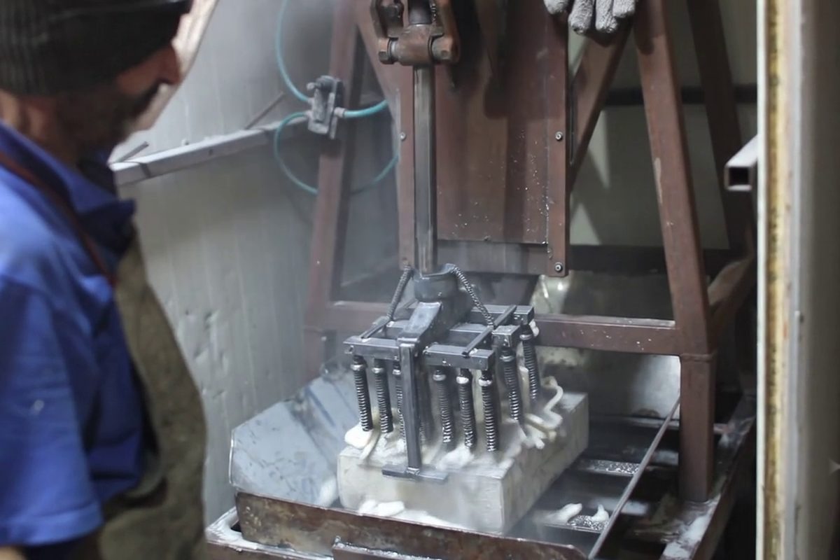 Seramik kalıp kırma makinesinde parçalanıyor, metal döküm ortaya çıkıyor, Gerra atölyesi
